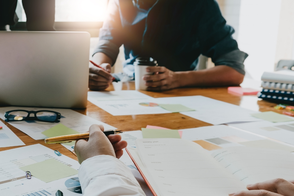 People working on a desk together for strategic planning