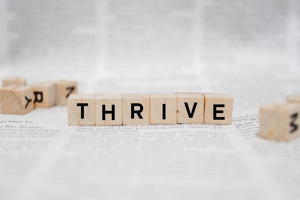 The word thrive in scrabble letters