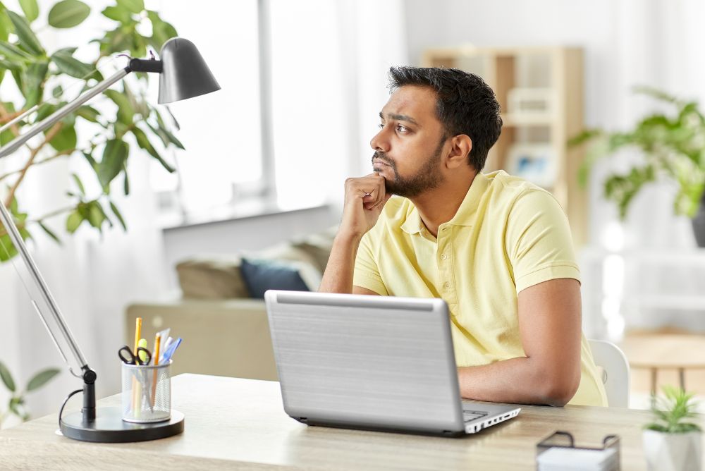 A person thinking with his computer in front of him